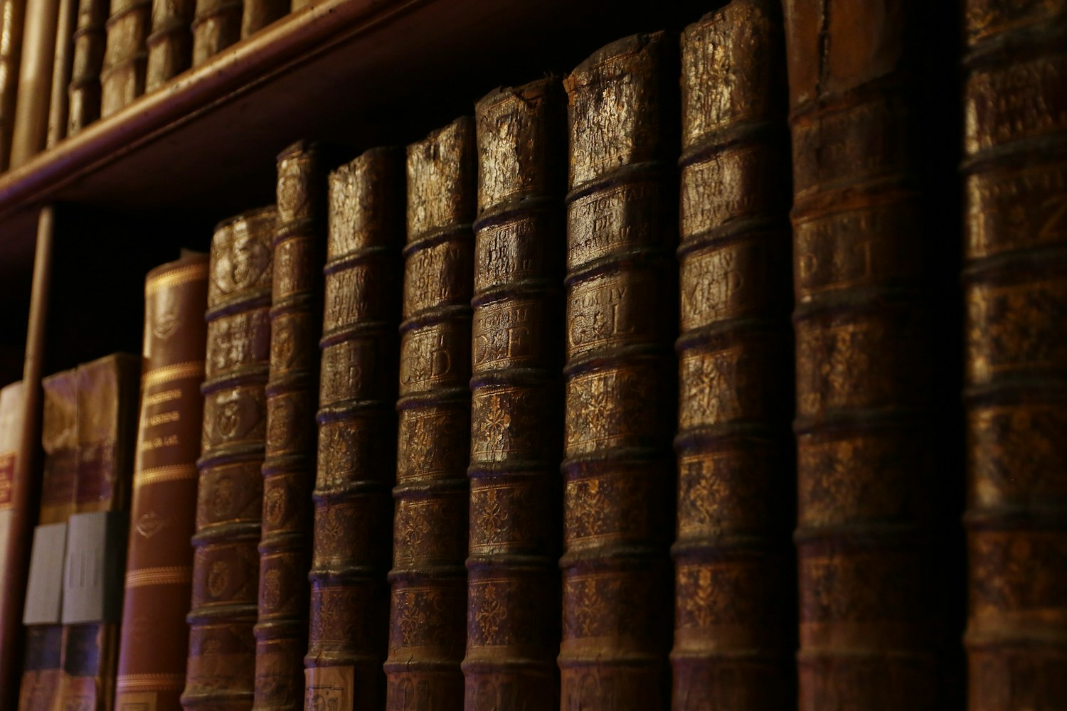 Antike Lederbücher und Schreibtischmaterialien in warmem Tageslicht — Innenraum-Stillleben für „Über uns"